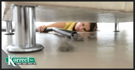 Woman vacuuming under couch