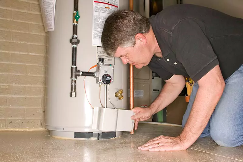 man inspecting a tank water heater