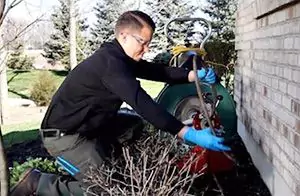 Plumber performing maintenance on drains