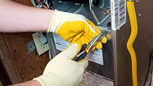 Person fixing furnace with tools