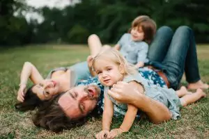 Mom, Dad, and two children laying in the grass