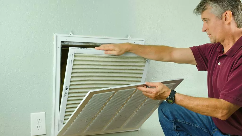 Person inspecting a ventilation system