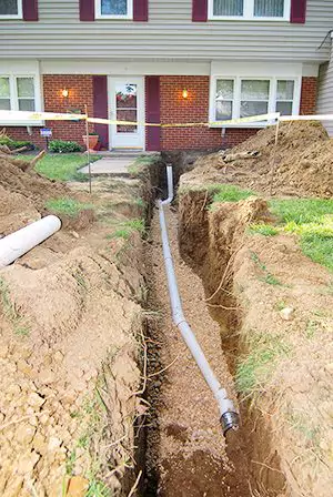 Pipe being dug up in front of a house